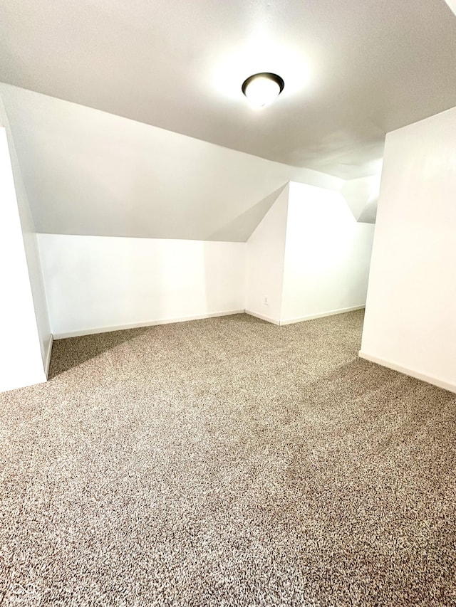 bonus room featuring vaulted ceiling, carpet, and baseboards