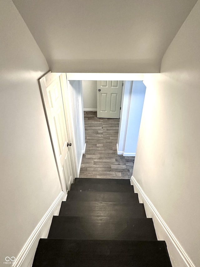 stairs with baseboards and wood finished floors