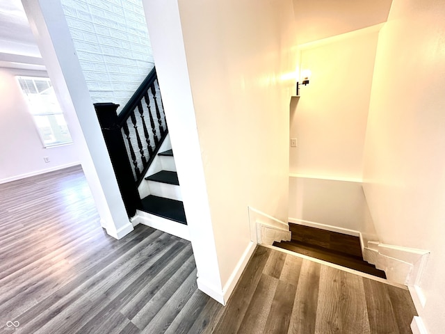 staircase with baseboards and wood finished floors