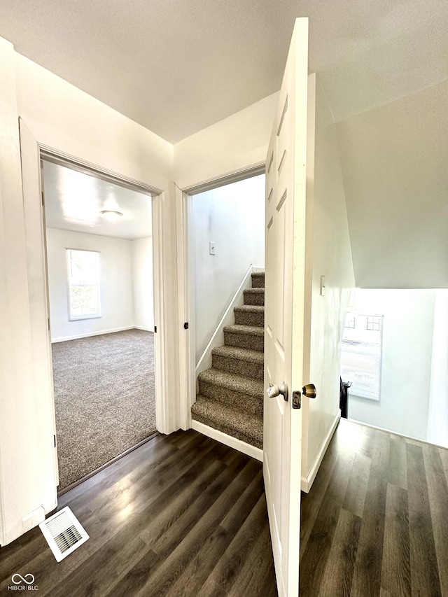 staircase featuring visible vents and wood finished floors