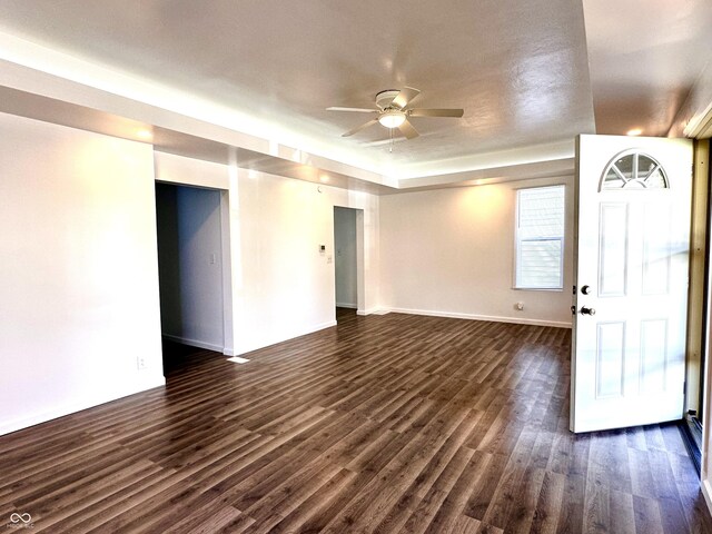 unfurnished living room featuring ceiling fan and dark hardwood / wood-style floors