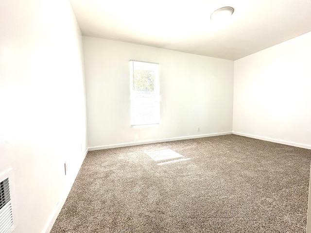 carpeted spare room featuring baseboards