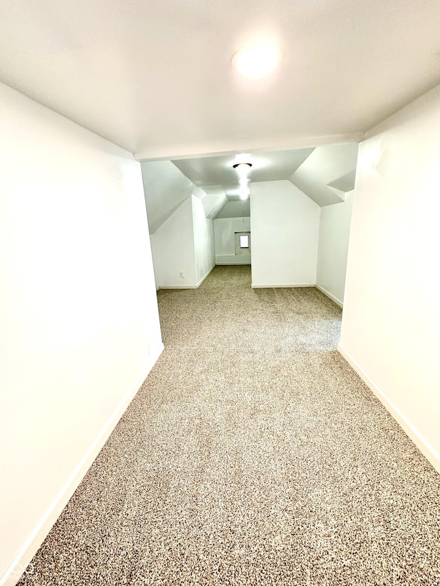 bonus room featuring carpet, vaulted ceiling, and baseboards