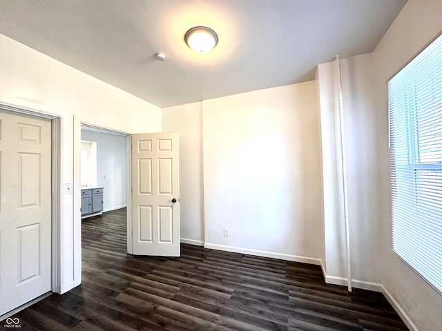 unfurnished room with dark wood-style floors and baseboards