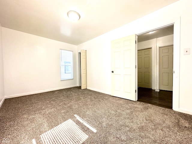 unfurnished bedroom with dark colored carpet