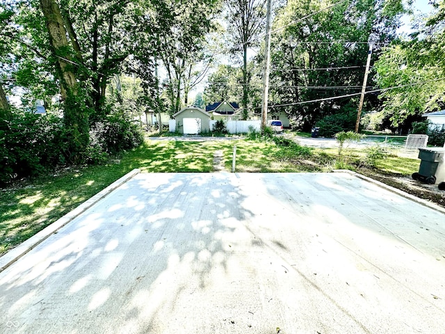 view of patio / terrace with a shed, fence, and an outbuilding