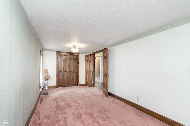 unfurnished bedroom featuring carpet flooring and a textured ceiling