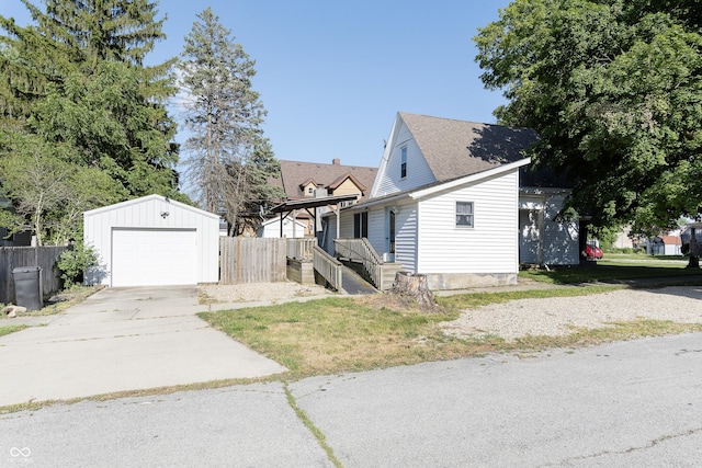 view of front facade with an outbuilding, a garage, and a front lawn