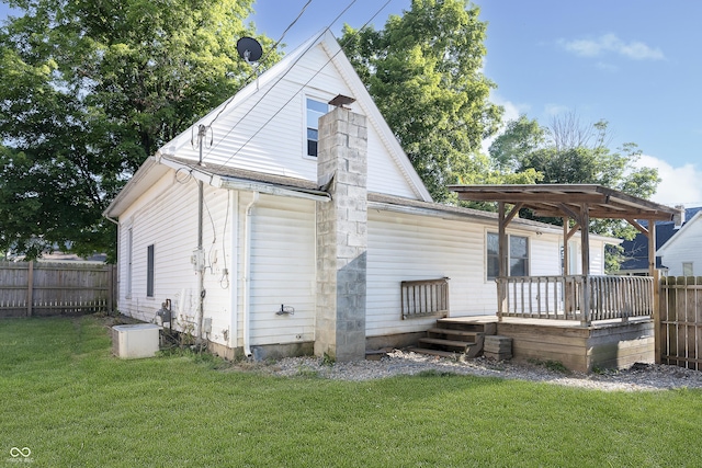 back of property with a yard and a deck