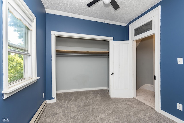 unfurnished bedroom featuring carpet floors, baseboard heating, ceiling fan, a textured ceiling, and a closet