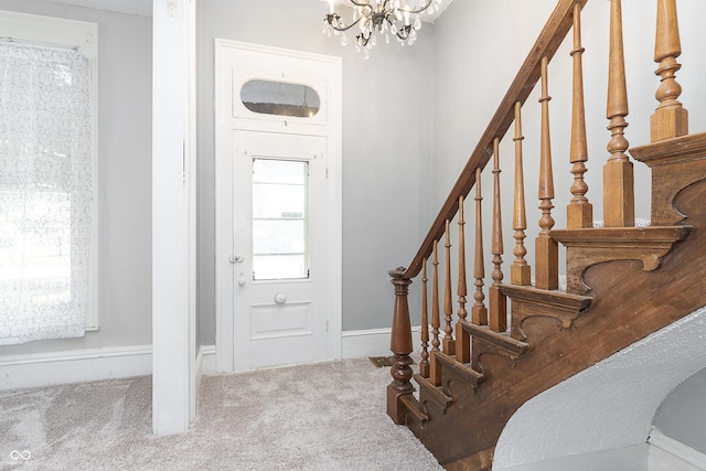 carpeted entrance foyer with an inviting chandelier