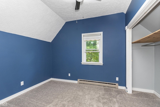 additional living space with vaulted ceiling, a textured ceiling, baseboard heating, ceiling fan, and carpet