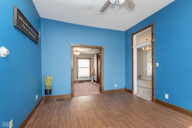 empty room with wood-type flooring, ceiling fan, and a textured ceiling