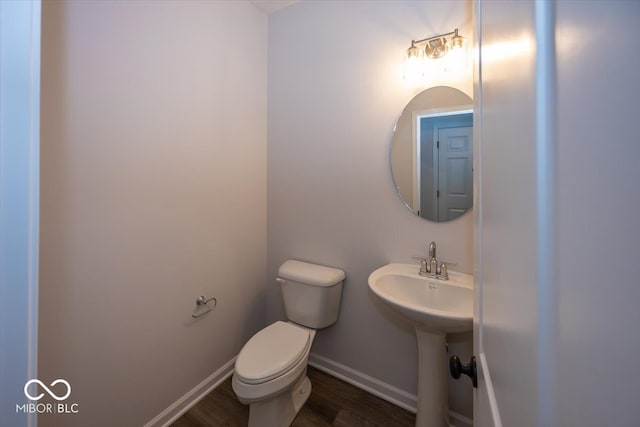 bathroom featuring wood-type flooring, toilet, and sink