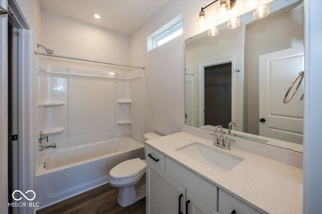 full bathroom with vanity, hardwood / wood-style floors, toilet, and washtub / shower combination