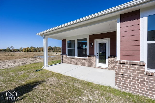 entrance to property featuring a lawn and a patio area