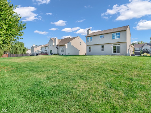 back of house with a lawn