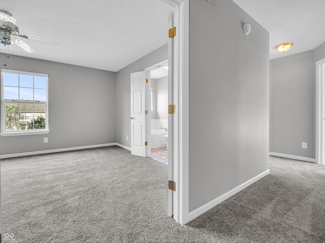 carpeted spare room featuring ceiling fan