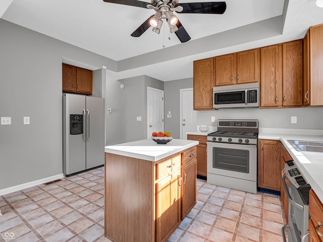 kitchen featuring a kitchen island, stainless steel appliances, light tile patterned floors, and ceiling fan