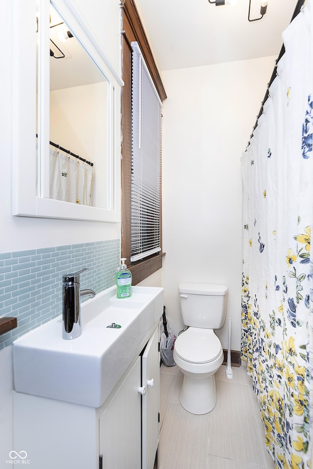 bathroom featuring tile patterned flooring, vanity, backsplash, and toilet