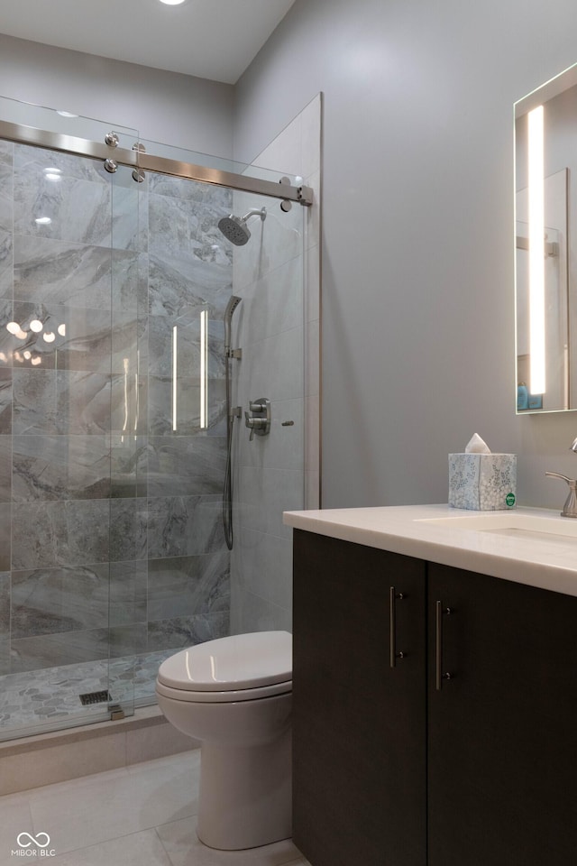 bathroom featuring tile patterned flooring, vanity, toilet, and an enclosed shower