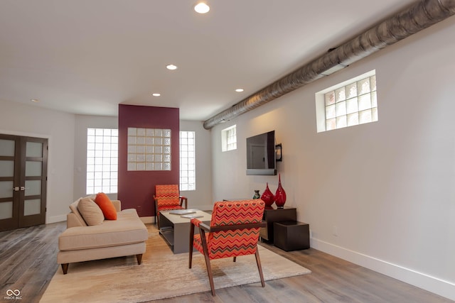 living room with french doors and light wood-type flooring