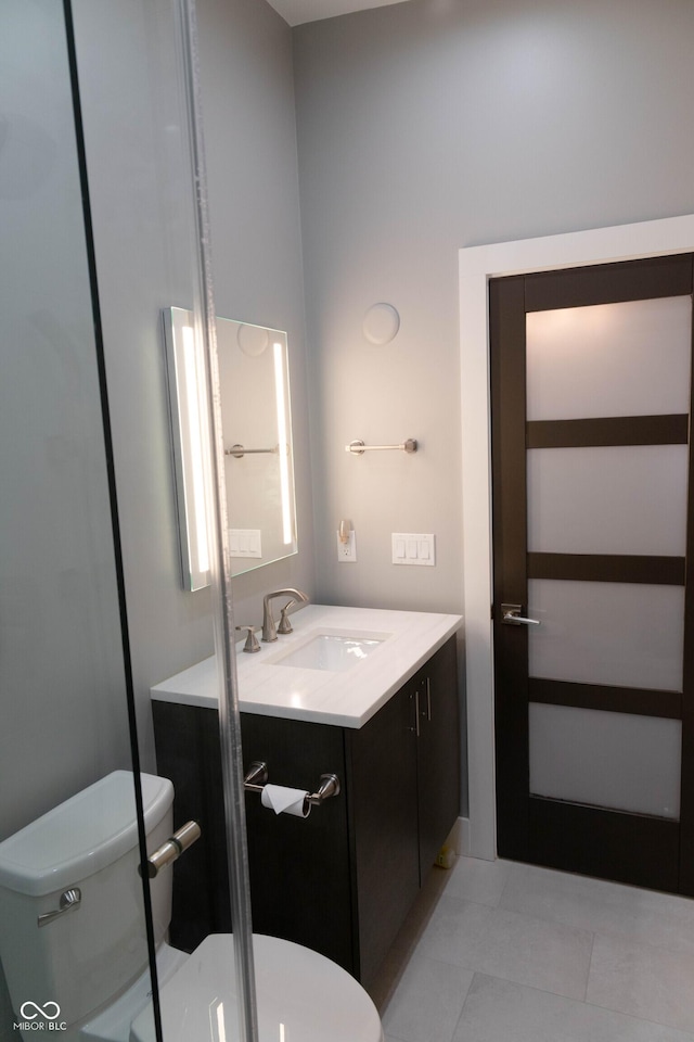 bathroom featuring tile patterned flooring, vanity, and toilet