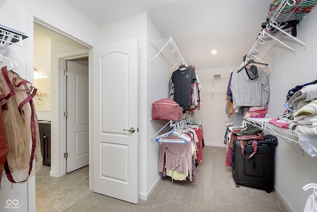 spacious closet featuring light colored carpet