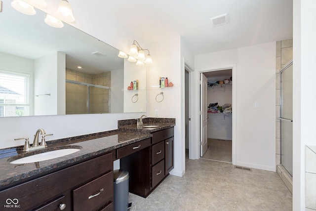 bathroom featuring vanity and a shower with shower door