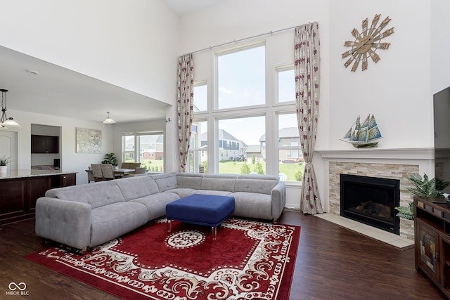 living room featuring dark hardwood / wood-style floors, a fireplace, and a high ceiling