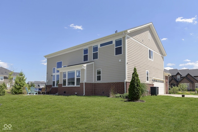 view of front of house with cooling unit, a garage, and a front lawn