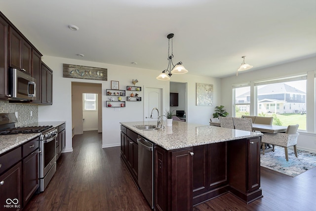 kitchen featuring sink, decorative backsplash, an island with sink, appliances with stainless steel finishes, and dark brown cabinetry