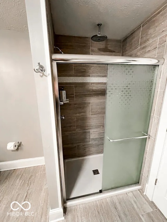 bathroom with an enclosed shower and a textured ceiling