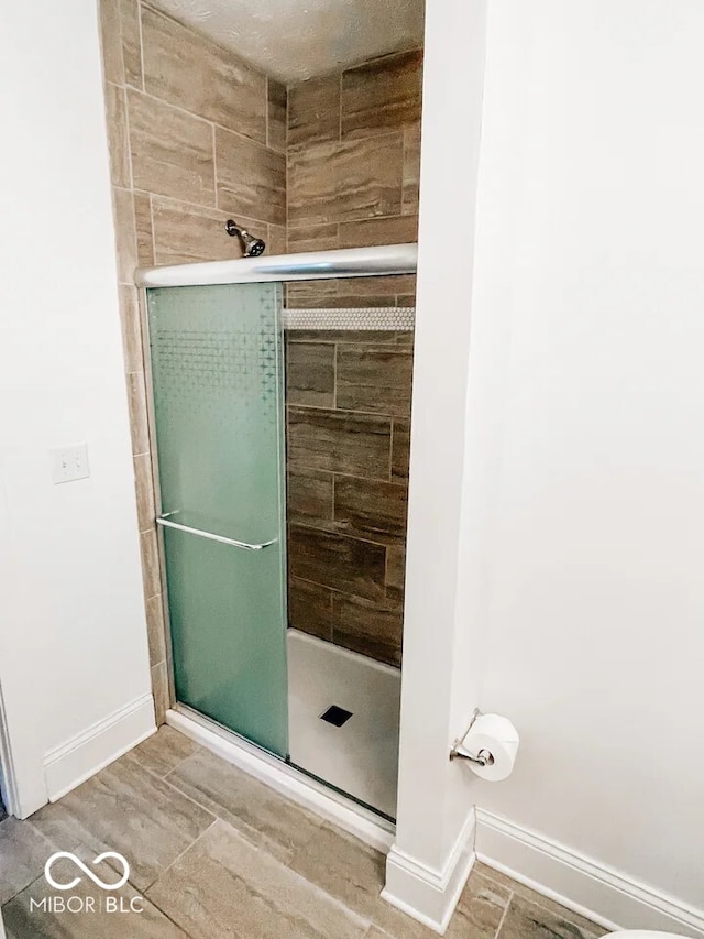 bathroom with hardwood / wood-style flooring and an enclosed shower