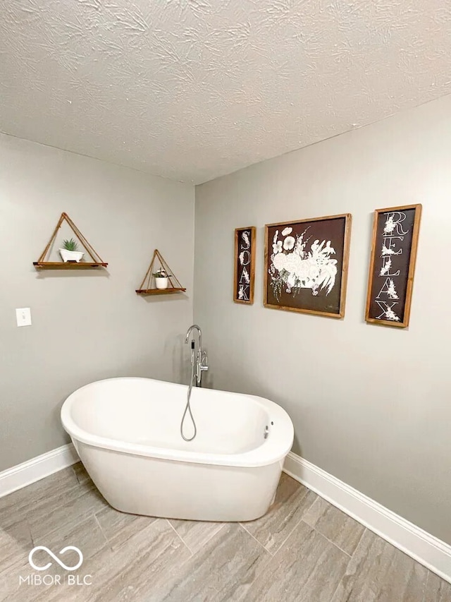 bathroom featuring a washtub and a textured ceiling