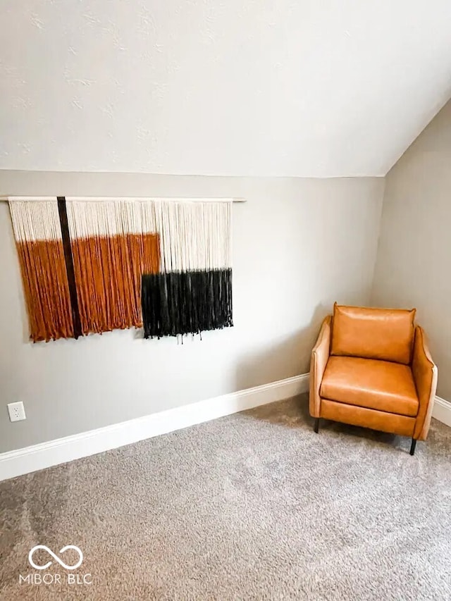 sitting room featuring carpet flooring and lofted ceiling