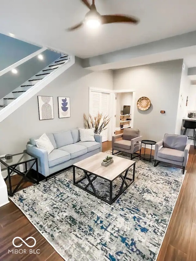 living room featuring ceiling fan and dark wood-type flooring