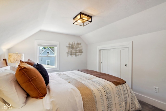 carpeted bedroom featuring a closet and vaulted ceiling