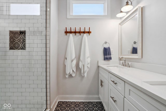 bathroom featuring tile patterned floors, vanity, and a tile shower