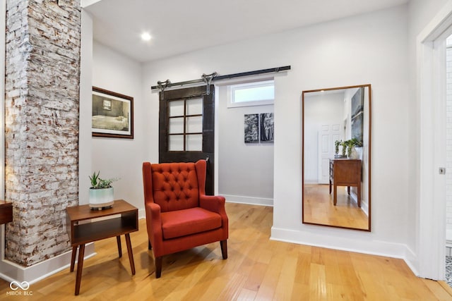 living area with a barn door and light wood-type flooring