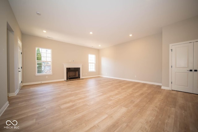 7936 Beaumont Green Pl, Indianapolis, IN 46250 - unfurnished living room with plenty of natural light, light wood-type flooring, a fireplace, and recessed lighting
