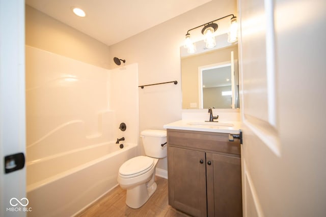 full bathroom featuring hardwood / wood-style flooring, vanity, toilet, and washtub / shower combination