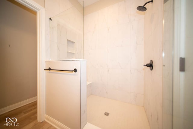 bathroom with hardwood / wood-style flooring and a tile shower