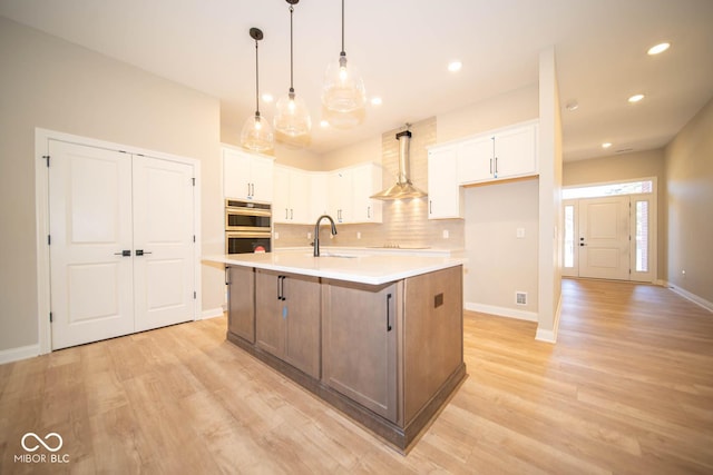 7936 Beaumont Green Pl, Indianapolis, IN 46250 - kitchen featuring double oven, light wood-style flooring, tasteful backsplash, white cabinets, and recessed lighting