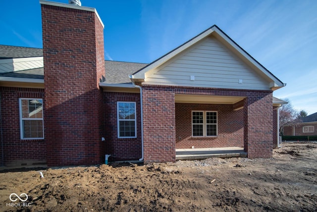 7936 Beaumont Green Pl, Indianapolis, IN 46250 - back of house with a chimney, brick siding, and roof with shingles
