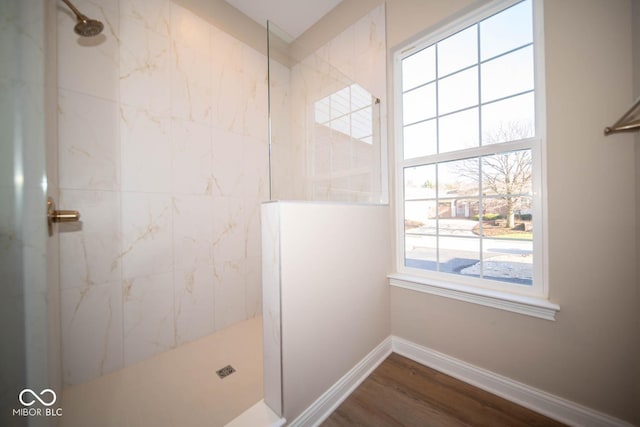 bathroom featuring hardwood / wood-style flooring and tiled shower