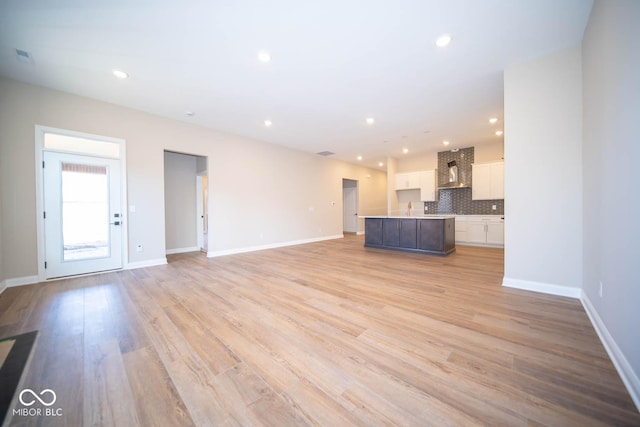 unfurnished living room with light wood-type flooring and sink