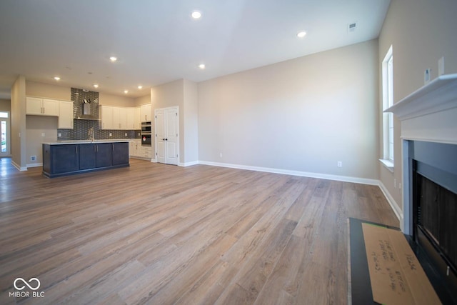 kitchen featuring white cabinetry, a kitchen island with sink, a healthy amount of sunlight, and sink