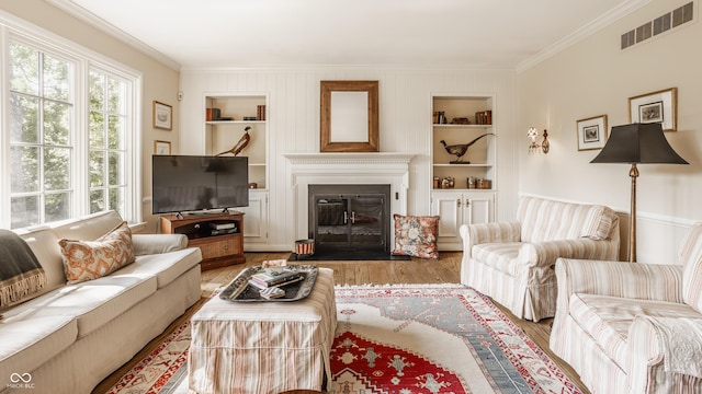 living room featuring crown molding, hardwood / wood-style floors, and built in features