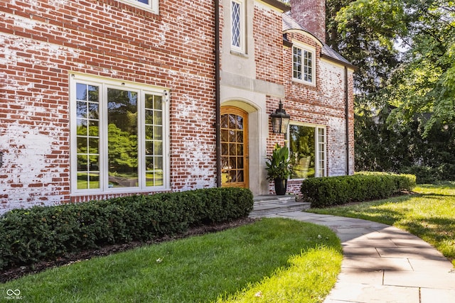 view of exterior entry with a yard